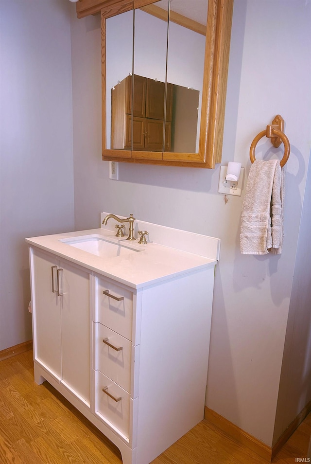 bathroom with vanity, baseboards, and wood finished floors