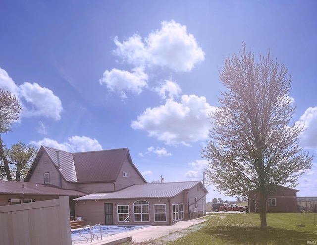 exterior space featuring a yard, fence, metal roof, and a patio area