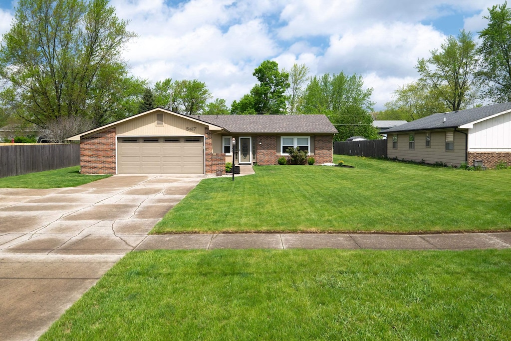 5417 Trier Rd, Fort Wayne, IN 46815 - single story home featuring a front lawn, fence, brick siding, concrete driveway, and an attached garage