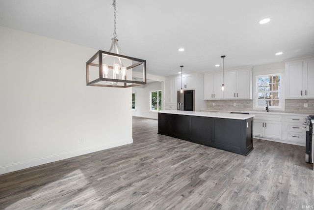 kitchen featuring backsplash, stainless steel appliances, a wealth of natural light, and light wood-type flooring