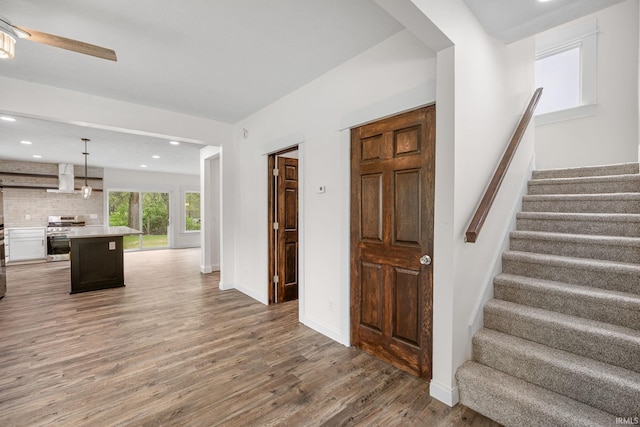 interior space featuring recessed lighting, a ceiling fan, baseboards, and wood finished floors