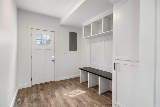 mudroom with baseboards, electric panel, wood finished floors, and visible vents