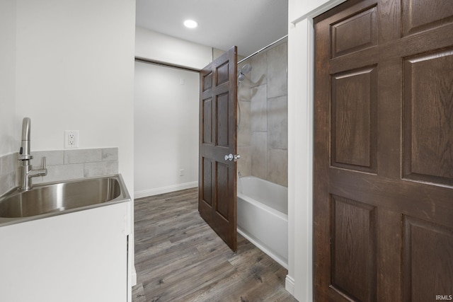 full bath featuring a sink, recessed lighting, baseboards, tub / shower combination, and wood finished floors