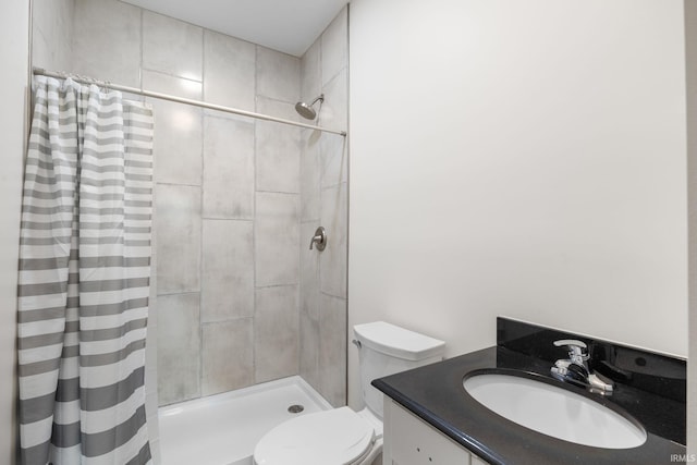 full bath featuring vanity, toilet, and tiled shower