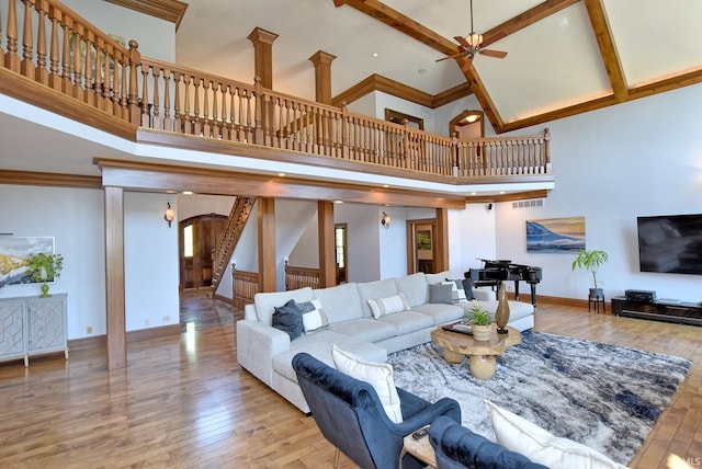 2200 Speaker Rd, Evansville, IN 47712 - living area with arched walkways, hardwood / wood-style flooring, a towering ceiling, ceiling fan, and stairway