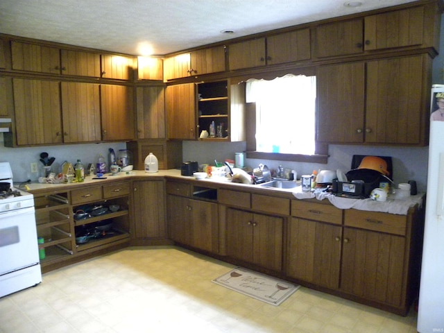 8207 Lehman Rd, Worthington, IN 47471 - kitchen with white range with gas cooktop, light flooring, open shelves, light countertops, and a sink