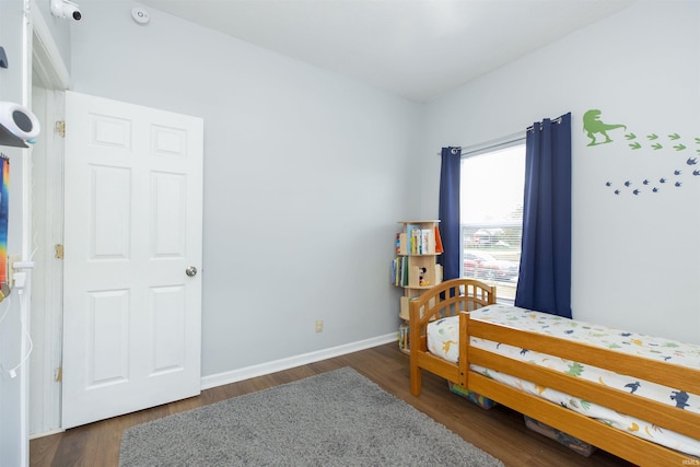 bedroom featuring baseboards and wood finished floors