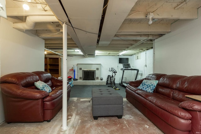 living room featuring a brick fireplace and unfinished concrete floors