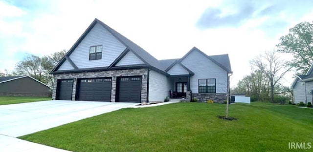 view of front of property with concrete driveway, a front yard, an attached garage, and stone siding