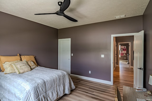 4663 Beringer Dr, Lafayette, IN 47909 - bedroom featuring wood finished floors, a textured ceiling, visible vents, ceiling fan, and baseboards