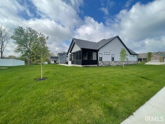 view of side of home with a yard and a sunroom