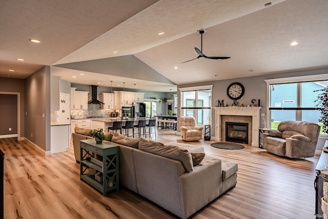 4663 Beringer Dr, Lafayette, IN 47909 - living room featuring baseboards, ceiling fan, vaulted ceiling, a fireplace, and light wood-type flooring