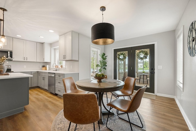 dining space featuring baseboards, french doors, recessed lighting, and light wood-style flooring