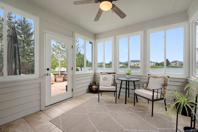 sunroom / solarium with a ceiling fan, a wealth of natural light, and a water view
