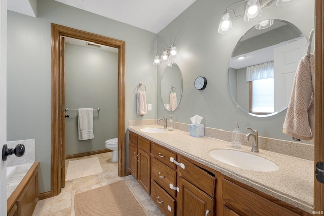 full bath featuring double vanity, toilet, baseboards, and a sink