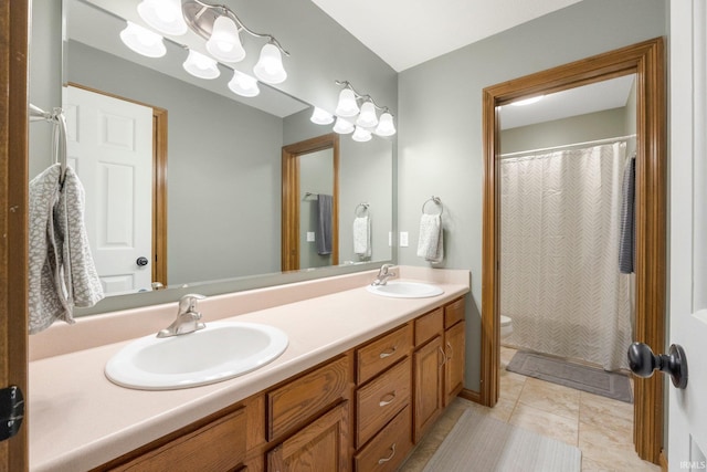 bathroom featuring double vanity, a sink, curtained shower, and toilet