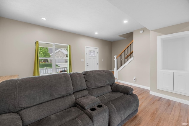 living area featuring recessed lighting, baseboards, stairway, and light wood-style floors