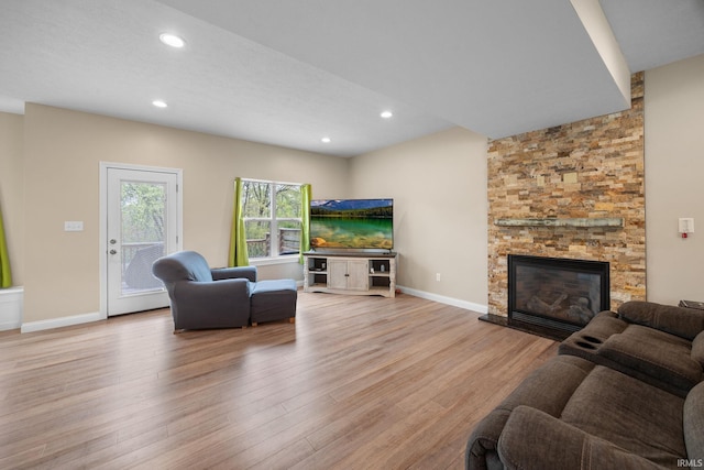 living area with light wood-style floors, baseboards, a fireplace, and recessed lighting