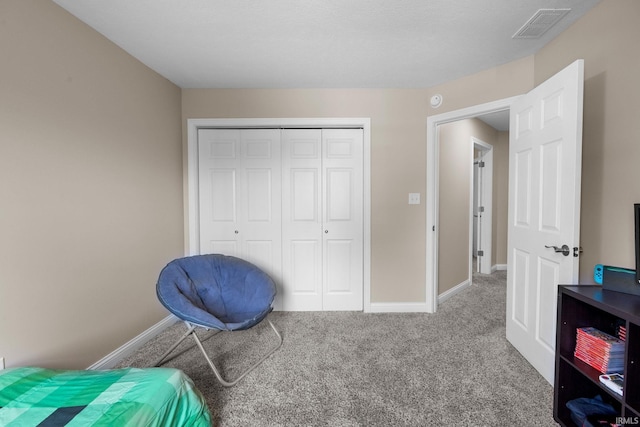 carpeted bedroom featuring baseboards, visible vents, and a closet