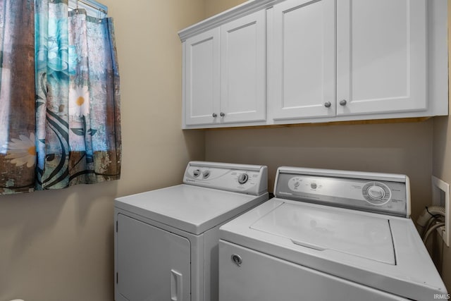 washroom featuring cabinet space and independent washer and dryer