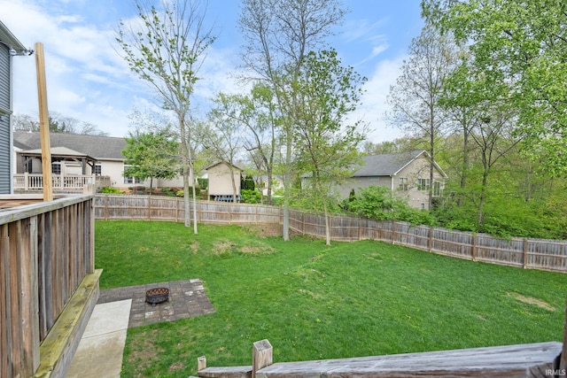 view of yard featuring a fenced backyard, an outdoor fire pit, and a residential view