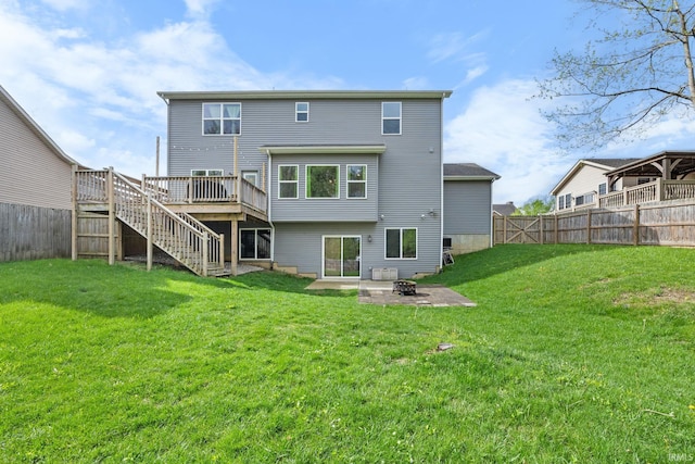 rear view of house featuring a fenced backyard, a fire pit, stairway, and a deck