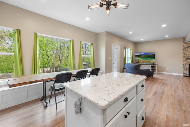 kitchen featuring light wood-style floors, a kitchen island, recessed lighting, and white cabinetry
