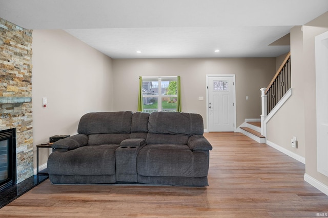 living room with a fireplace, baseboards, stairway, recessed lighting, and light wood-style flooring
