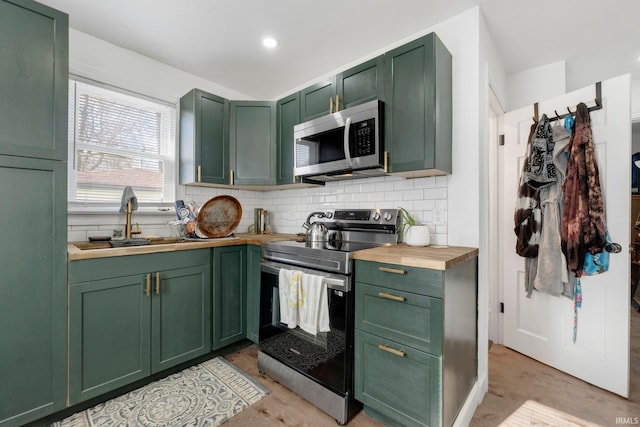 2819 Witchwood Dr, Fort Wayne, IN 46809 - kitchen with butcher block countertops, green cabinetry, appliances with stainless steel finishes, and backsplash