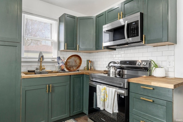 2819 Witchwood Dr, Fort Wayne, IN 46809 - kitchen featuring green cabinetry, appliances with stainless steel finishes, a sink, wooden counters, and decorative backsplash