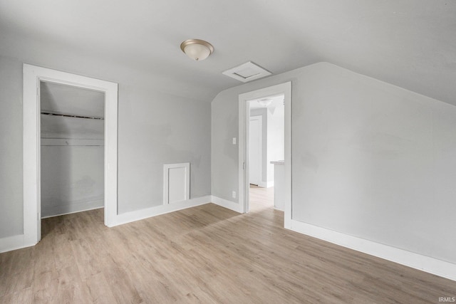 additional living space featuring attic access, baseboards, vaulted ceiling, and light wood finished floors