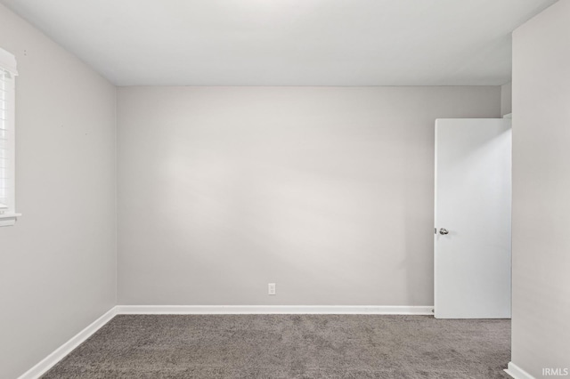 empty room featuring carpet flooring and baseboards