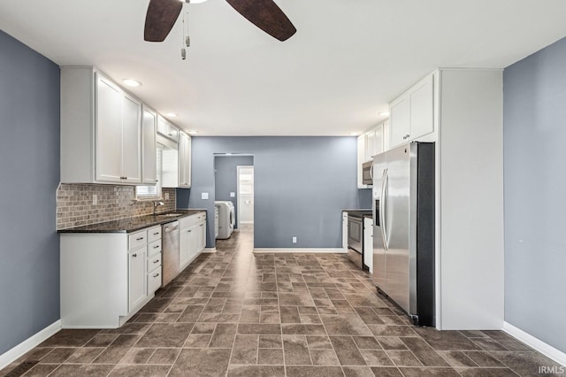 kitchen featuring dark countertops, baseboards, ceiling fan, white cabinets, and appliances with stainless steel finishes