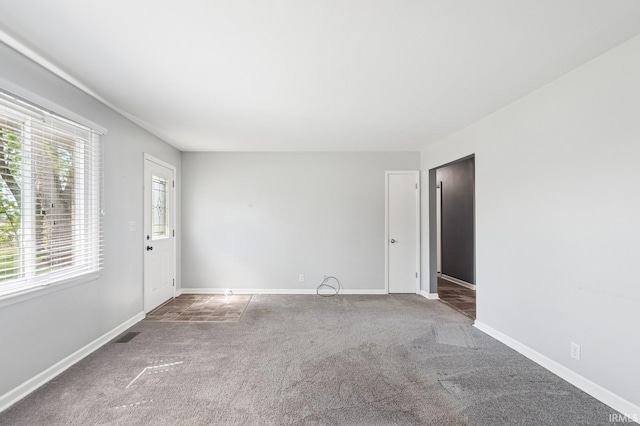 carpeted spare room featuring baseboards