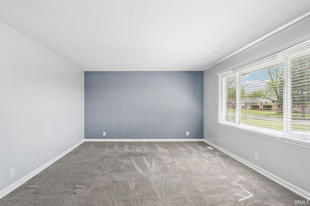 carpeted empty room featuring baseboards