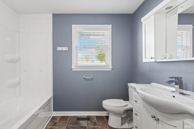 full bathroom with baseboards, bathing tub / shower combination, toilet, and vanity
