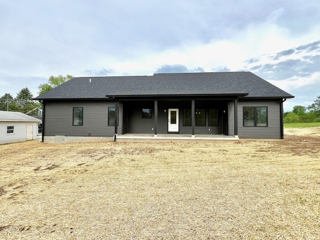 back of property with a shingled roof and a porch
