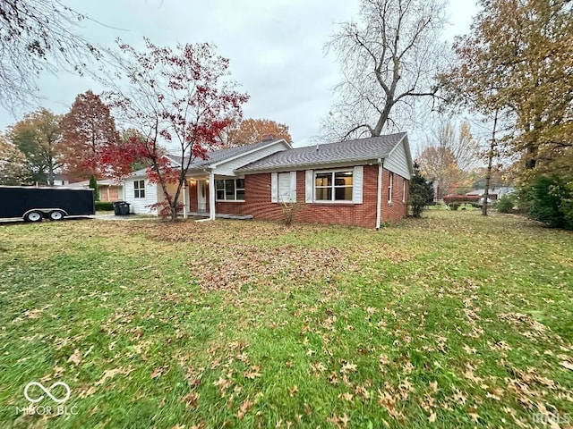 single story home featuring brick siding and a front lawn