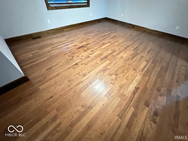 interior space with baseboards, visible vents, and dark wood-type flooring