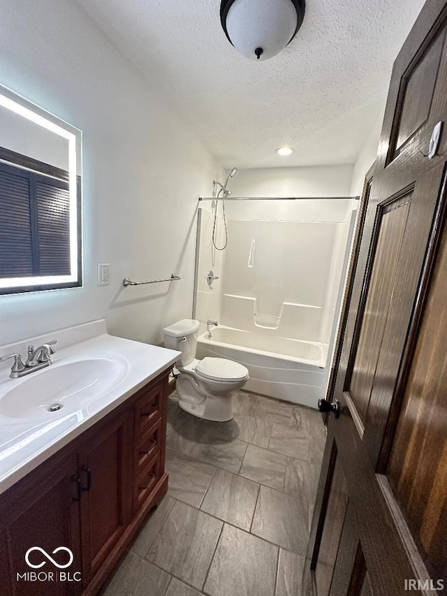 full bath featuring vanity, a textured ceiling, toilet, and shower / washtub combination