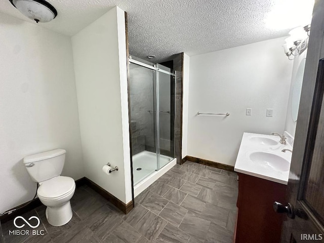 full bathroom featuring a sink, baseboards, a stall shower, and a textured ceiling