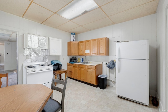 kitchen featuring light countertops, light floors, a drop ceiling, and white appliances