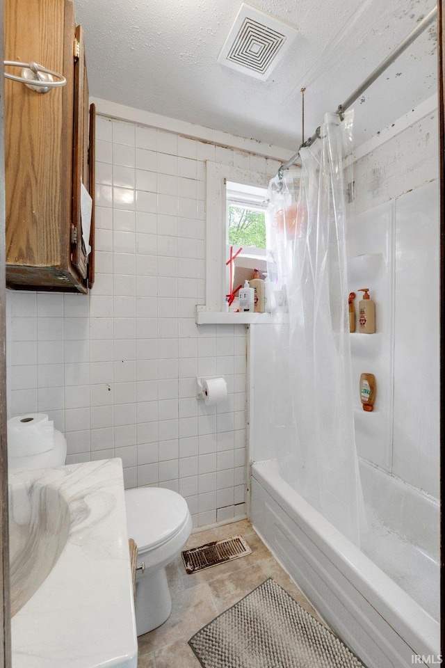 bathroom with visible vents, shower / bath combination with curtain, toilet, and tile walls