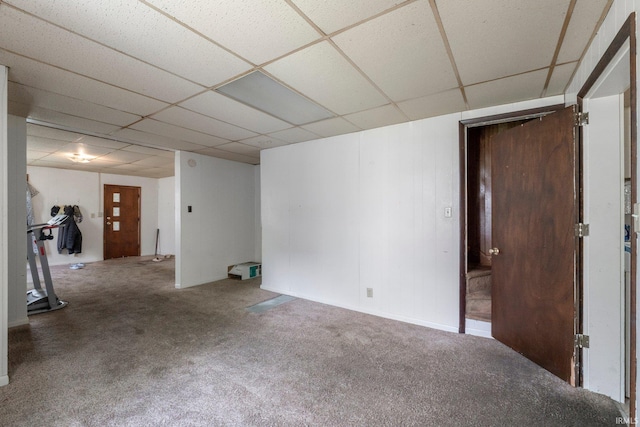carpeted spare room featuring a drop ceiling