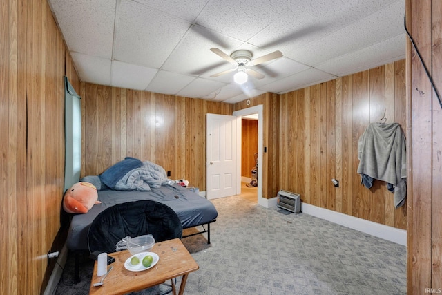 bedroom with carpet floors, wood walls, and a paneled ceiling