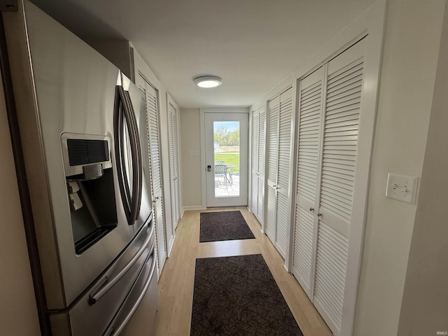 entryway with baseboards and light wood finished floors