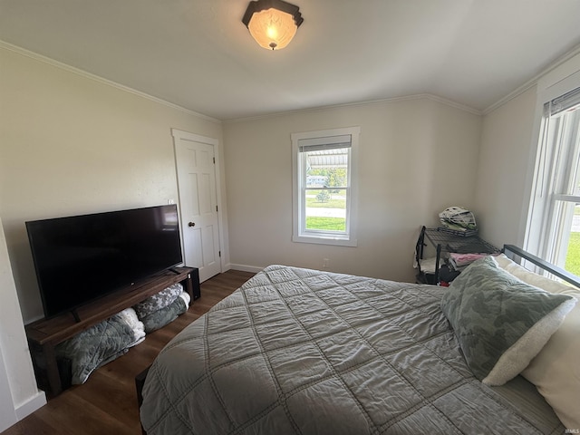 bedroom featuring crown molding, wood finished floors, and multiple windows
