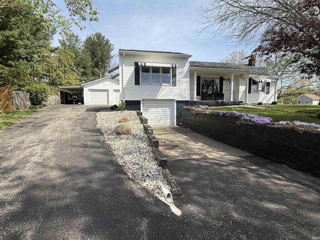 view of front facade featuring fence, driveway, and a chimney