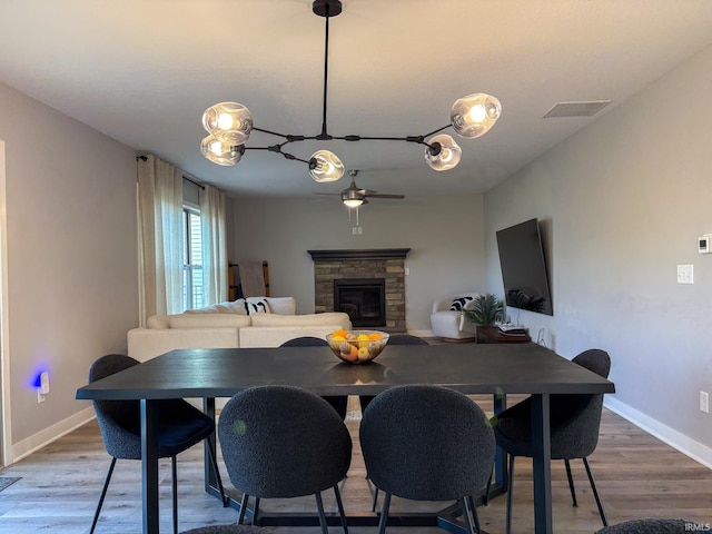 dining area featuring visible vents, baseboards, ceiling fan, and wood finished floors