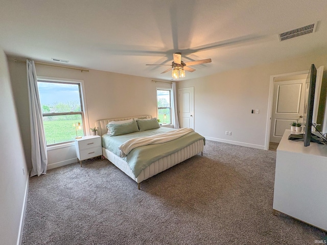bedroom featuring baseboards, a ceiling fan, dark colored carpet, and visible vents